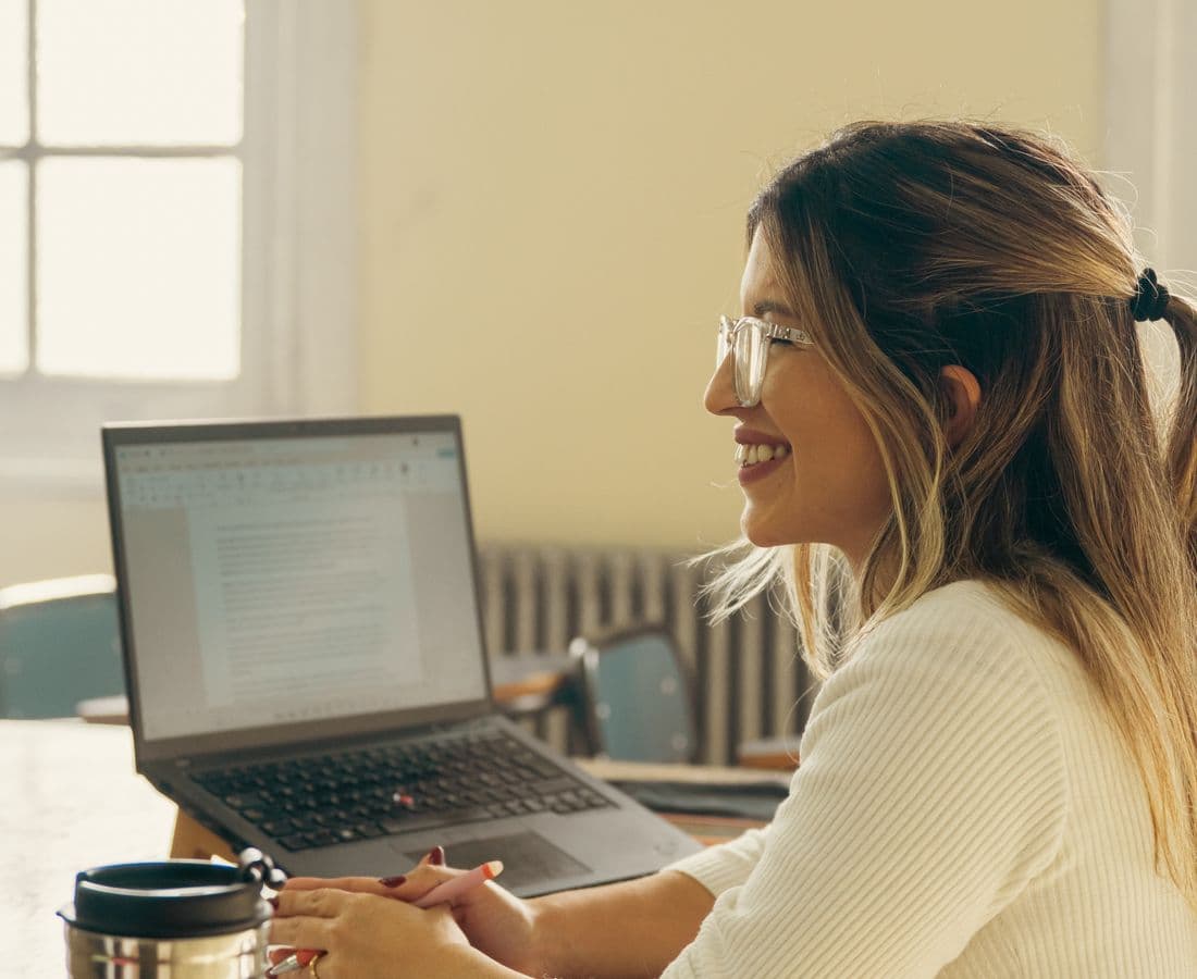 A teacher reviewing student work on a laptop